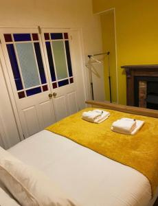 a bedroom with a bed with two towels on it at Coronation Place in Troed-y-rhiw