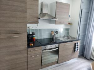 a small kitchen with wooden cabinets and a sink at Maison au pied du château in Châteaudun