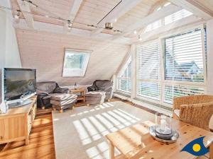 a living room with couches and a tv and a table at Ferienhaus Melle 01 in Kolpinsee