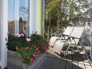 un porche con 2 sillas y flores en una casa en Ferienwohnung Bergstraße 04 Whg 02, en Ahlbeck