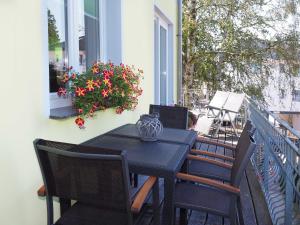 una mesa negra y sillas en un balcón con flores en Ferienwohnung Bergstraße 04 Whg 02, en Ahlbeck