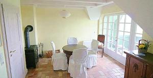 a dining room with a table and white chairs at Haus am Achterwasser Whg "Klabautermann" in Ueckeritz