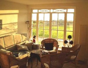 a living room with a couch and a table with chairs at Haus am Achterwasser Whg "Kapitän Nemo" in Ueckeritz