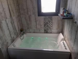 eine weiße Badewanne im Bad mit Fenster in der Unterkunft Magnifique villa avec piscine in Cestas