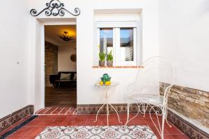 - une terrasse couverte avec 2 chaises et une table dans l'établissement Apartamentos Gaviota, à Valencina de la Concepción