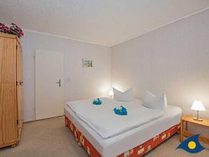 a bedroom with a large white bed with two stuffed animals on it at Haus Ueckeritz Bauernsuite in Ueckeritz