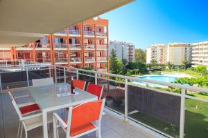 a balcony with a table and chairs and a pool at UHC Ventura Park Apartments in Salou