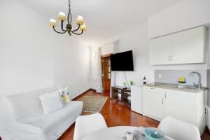 a living room with a white couch and a kitchen at Carmelo y Carmela 2 in Teror +18 photos