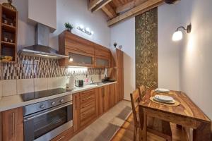a kitchen with wooden cabinets and a wooden table at Dream apartment in Bratislava