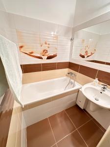 a bathroom with a bath tub and a sink at Hotel N in Znojmo