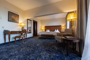 布爾加斯的住宿－普利莫雷茲格蘭德Spa酒店，配有一张床和一张书桌的酒店客房