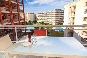a balcony with a table with wine glasses on it at UHC Ventura Park Apartments in Salou
