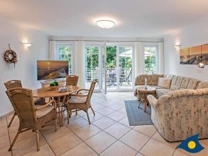 sala de estar con sofá, mesa y sillas en Parkresidenz "Zwei Linden" App 02 "Enjoy" en Heringsdorf