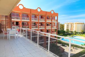 un edificio de apartamentos con balcón y piscina en UHC Ventura Park Apartments, en Salou