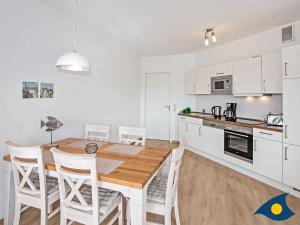 cocina y comedor con mesa de madera y sillas en Villa Hügel B 02 "Zaczernie", en Ahlbeck