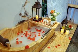 drewniana wanna z opadłymi kwiatami i świecami w obiekcie Homestay#CL#OldQuarterView#UniqueBalcony w mieście Hanoi +16 zdjęć