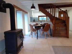 a kitchen with a stove and a table with chairs at La Vieille Maison aux Canards in Neuvic-Entier