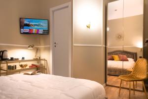 - une chambre avec un lit et une télévision murale dans l'établissement Fair Suite Roma Termini, à Rome