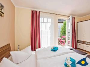 ヘリングスドルフにあるVilla Ilse Whg 03のベッド2台とバルコニーが備わるホテルルームです。