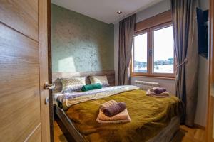 um quarto com uma cama com toalhas em Luxury Kalman Centar Apartman em Zlatibor mais 37 fotografias