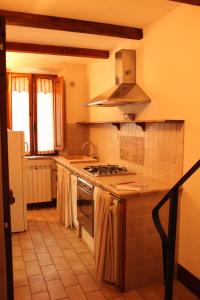 a kitchen with a sink and a stove top oven at Trilocale nel centro storico in Montemerano +3 photos