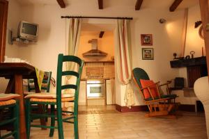 a kitchen with a bunch of chairs in a room at Trilocale nel centro storico in Montemerano