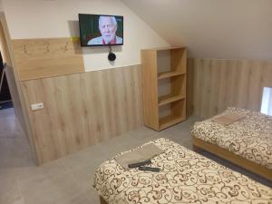 Habitación con 2 camas y TV en la pared. en ROOMS FOR RENT, en Panevėžys