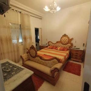 a bedroom with a large bed and a couch at S+2 skanes RDC enozha in Monastir