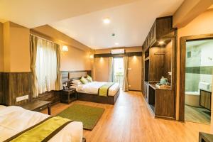 Cette chambre comprend deux lits et une télévision. dans l'établissement Purna's Museum Resort, à Lalitpur