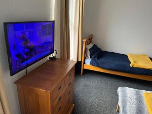 a bedroom with a flat screen tv and a bed at Eurovilla in Belfast