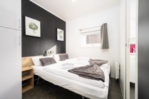 Un dormitorio con una cama blanca con una pared de acento negro en Mobilheim am Murner See - private Sauna + privater Badezuber, en Wackersdorf