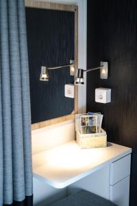 a bathroom with a vanity with a mirror and lights at Mobilheim am Murner See - private Sauna + privater Badezuber in Wackersdorf