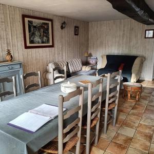 a dining room with a table and chairs and a couch at Le Moulin Neuf in Beaupréau