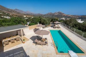 - une piscine bordée de chaises longues et de parasols dans l'établissement Aloni Villa with 180° SeaView, Private Pool & BBQ, 2km from Beach, à Plakias