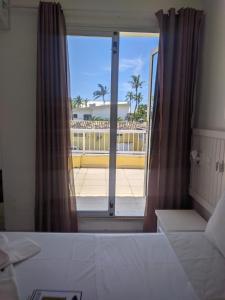 a bedroom with a window with a view of a building at Jequitiba Hotel Frente ao Mar in Guarujá