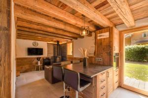 a kitchen with wooden ceilings and a large island with chairs at Chalet Pierre d Anatase in Saint-Gervais-les-Bains
