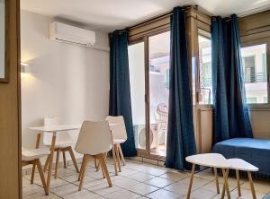 Zimmer mit einem Tisch, Stühlen und einem Bett in der Unterkunft Résidence Graziella Studio 301 in Juan-les-Pins