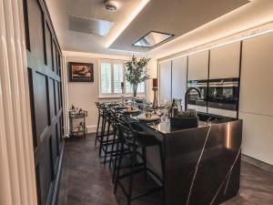 a kitchen with a long bar with stools at Whisk Away Cottage in Penrith
