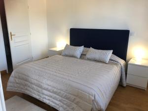 a bedroom with a large white bed with two lamps at Villa Médicis Trouville-sur-mer in Trouville-sur-Mer