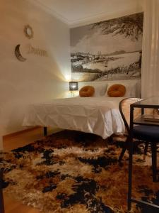 ビーゴにあるSuite Príncipeのベッドルーム1室(ベッド1台付)が備わります。壁には絵画が飾られています。