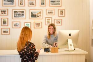 two women sitting at a desk with a computer at LEGASEA - Cascais Guesthouse in Cascais
