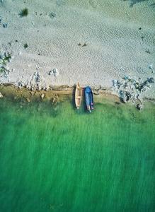 a car parked on the beach next to the water at Apartmani Konoba Starčevo in Virpazar