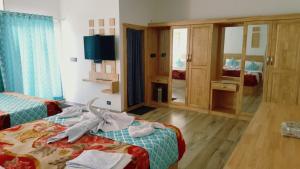 um quarto de hotel com duas camas e um espelho em Ivy paradise cottage (IV cottage) em Munnar