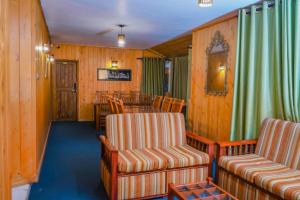 ein Wohnzimmer mit 2 Stühlen und einem Tisch in der Unterkunft Blue Moon Residency in Nuwara Eliya
