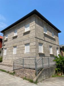 a stone building with a fence in front of it at Casa España Sol in Vigo