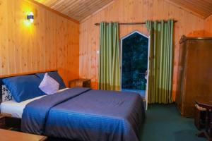 sypialnia z łóżkiem i dużym oknem w obiekcie Blue Moon Residency w mieście Nuwara Eliya