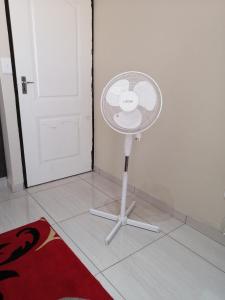 een witte ventilator op een vloer naast een deur bij Beautiful & Serene Airbnb house in Klerksdorp