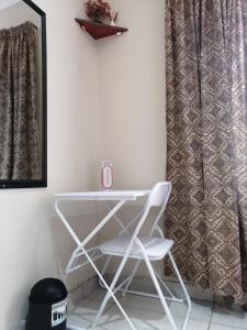uma cadeira branca num quarto com uma janela em Beautiful & Serene Airbnb house em Klerksdorp