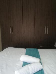 łóżko z dwoma ręcznikami i drewnianymi szafkami w obiekcie Beautiful & Serene Airbnb house w mieście Klerksdorp