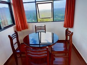 a dining room with a table and chairs and a window at Zadokz farmstay in Padinjarathara
